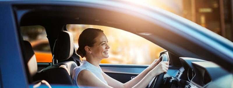 woman driving car in city setting